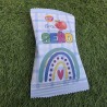 Diseño de arcoíris y nubes en tonos pastel suaves para etiqueta de snack.