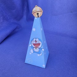 Diseño de cajita con forma de pirámide y temática de Doraemon en tonos pastel suaves.